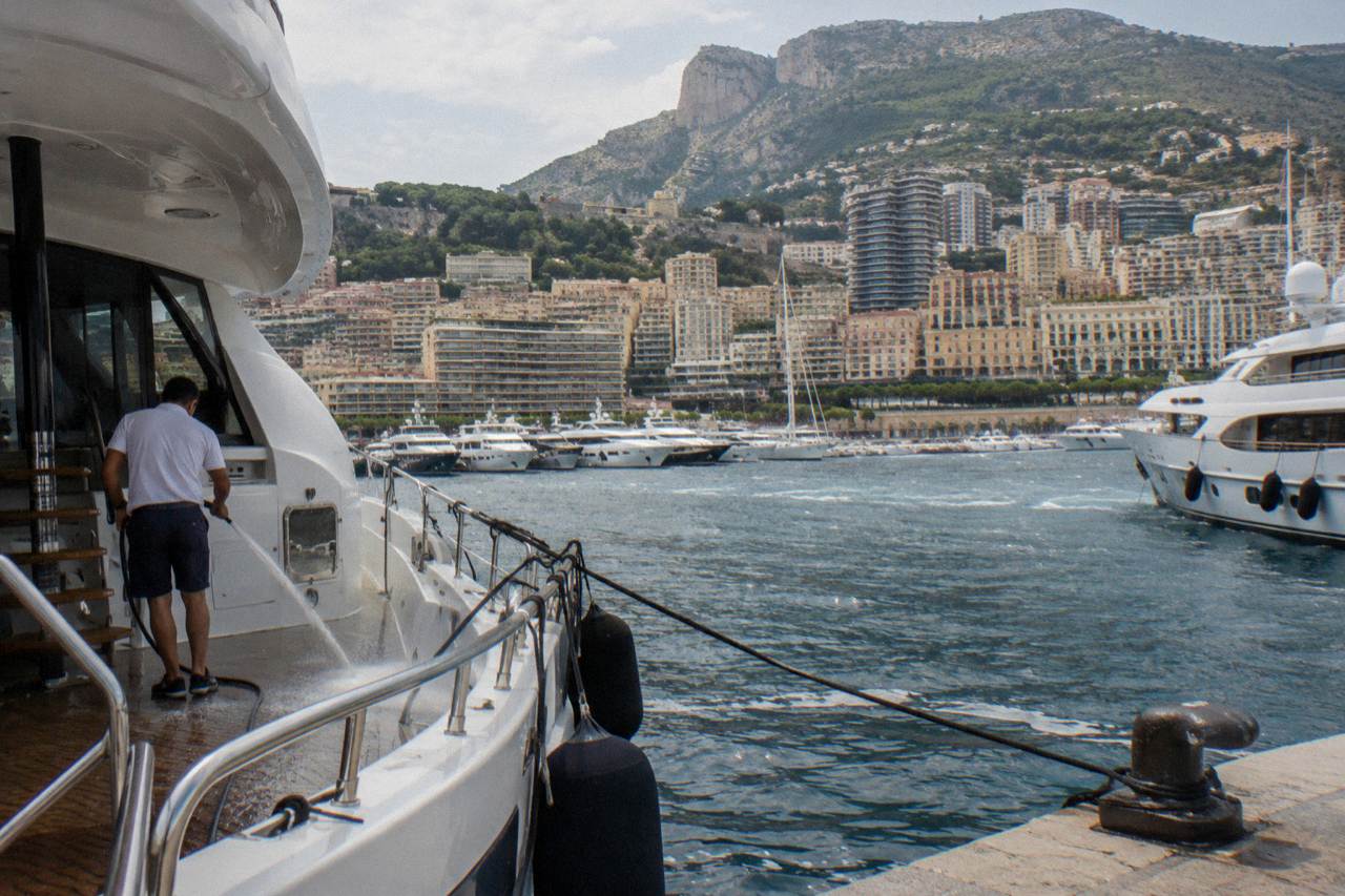 Harbor at Monaco with luxury yachts moored along the quays and hillsides rising behind the port