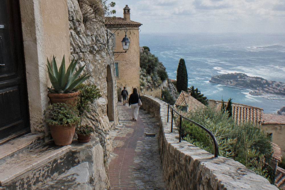Narrow stone street on a hillside old town with pastel buildings and sky above