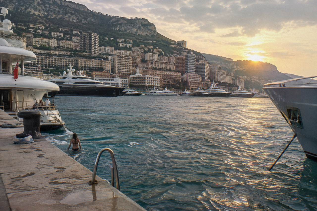 View over Monaco harbor with hills and apartment buildings above the water