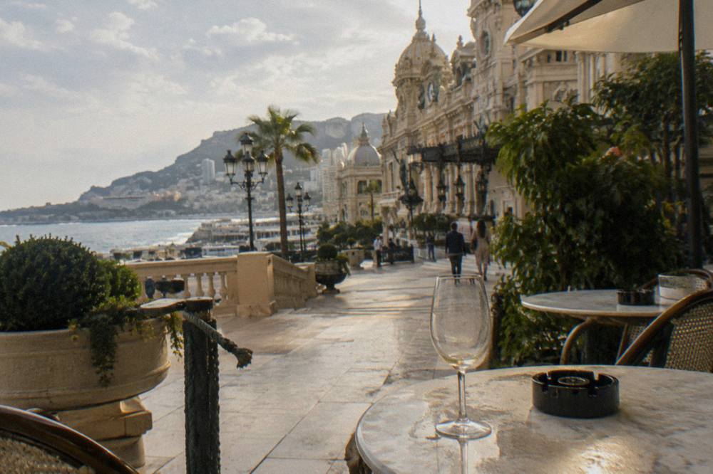 Exterior of the Casino de Monte-Carlo with its ornate facade and terrace cafe tables in daylight
