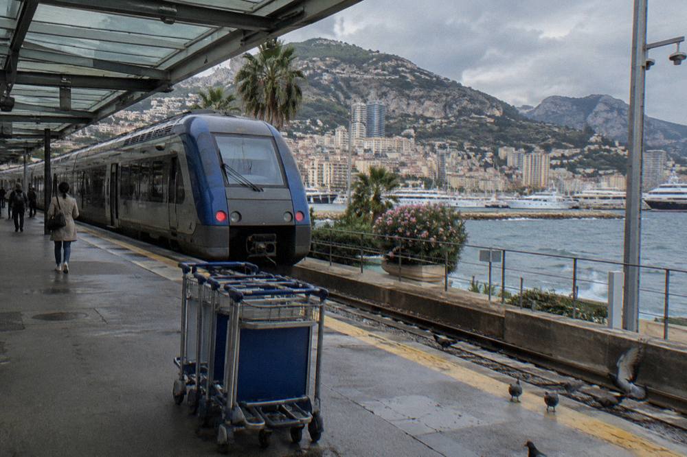 A regional TER train stopped at a station platform on the French Riviera coast