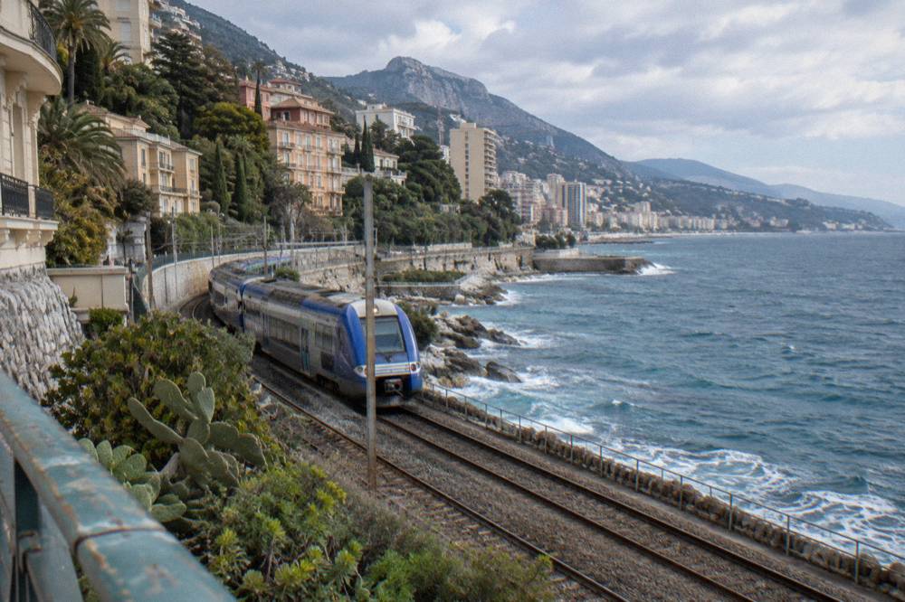 Train platform at Monaco station above the harbour with hills in the background