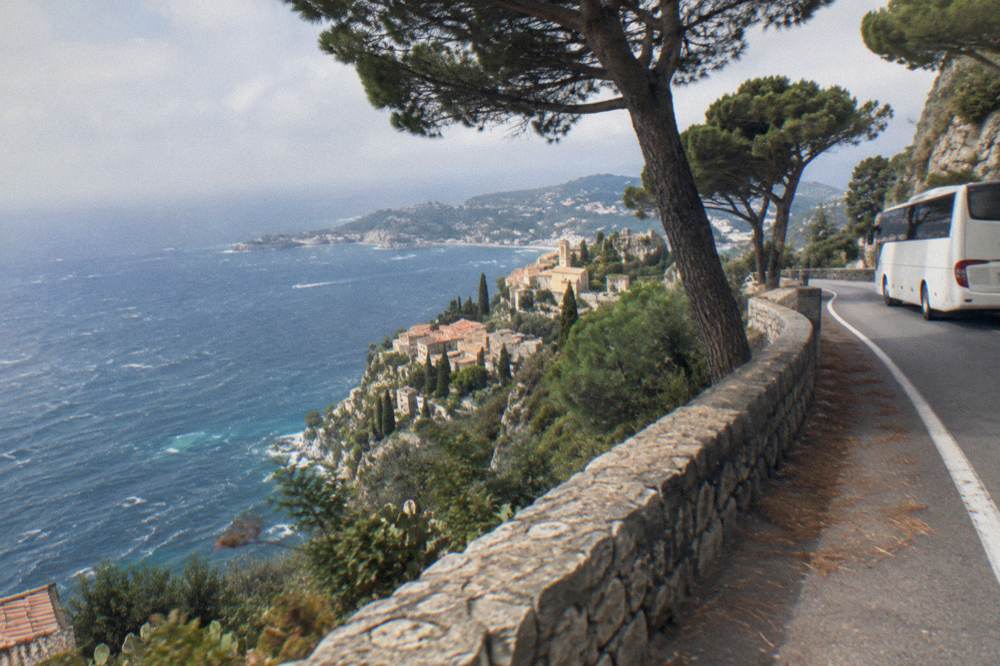 Cliffside coastal road between Nice and Monaco with blue sea and pine trees