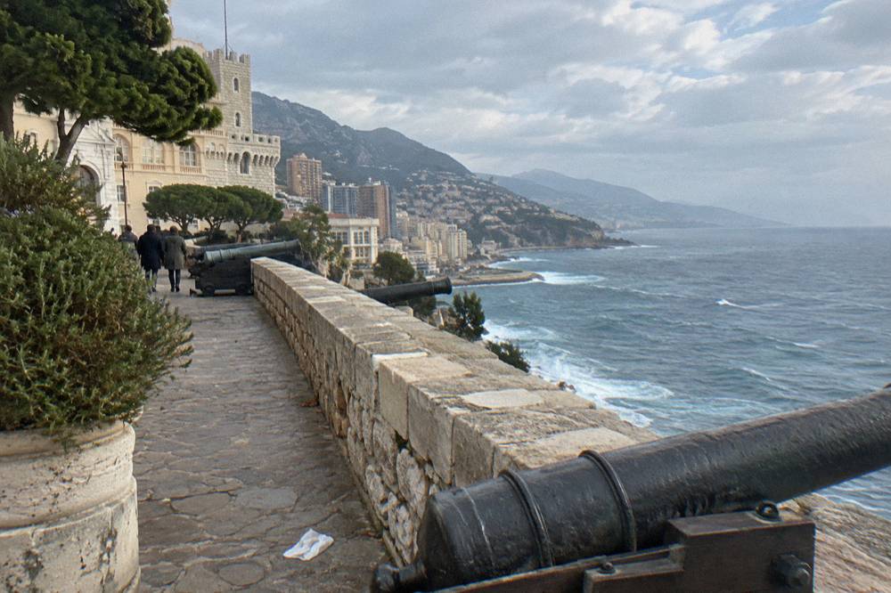 Stone rampart walkway above the Mediterranean with the coastline curving into the distance