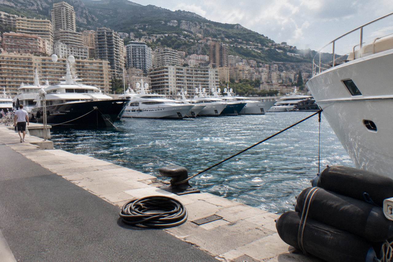 Harbor front of Monaco with yachts moored along the quay and hillside buildings above
