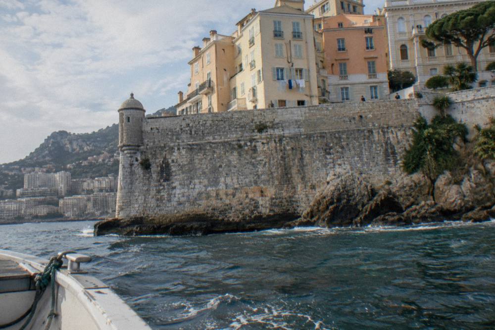 Old town buildings on the Rock of Monaco rising above a stone fortification wall