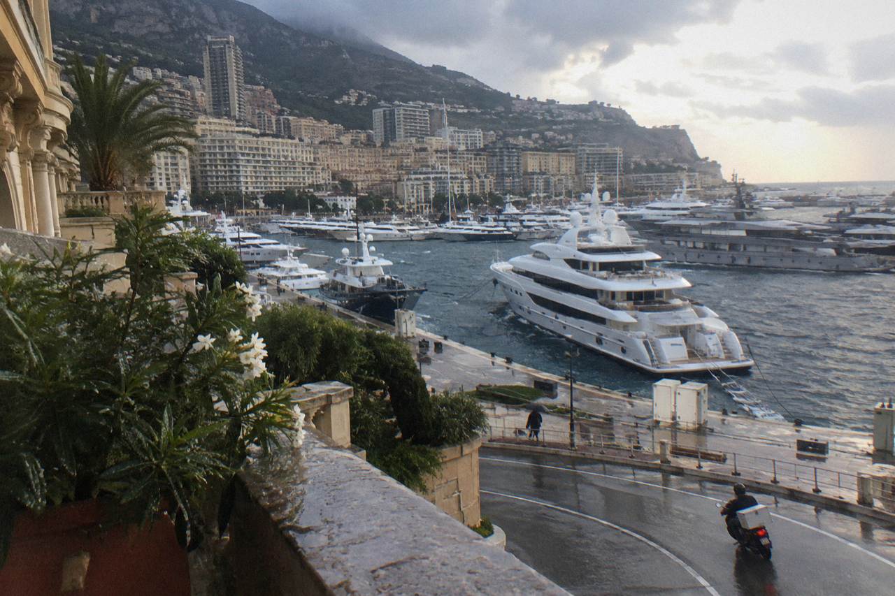 View over Monaco harbor with luxury yachts moored below hillside buildings