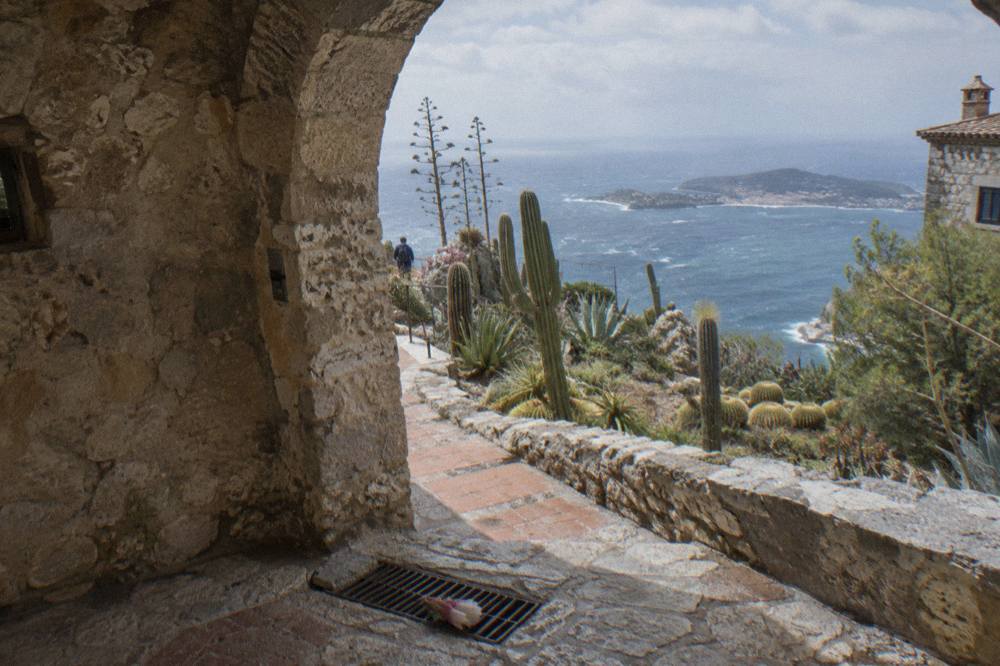 Narrow stone alley in a hilltop Riviera village with an arched passage overhead