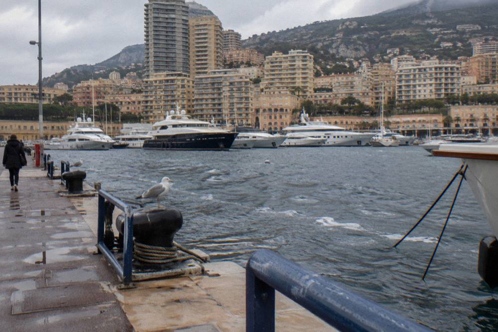Harbor filled with yachts backed by tall apartment buildings on a Mediterranean hillside