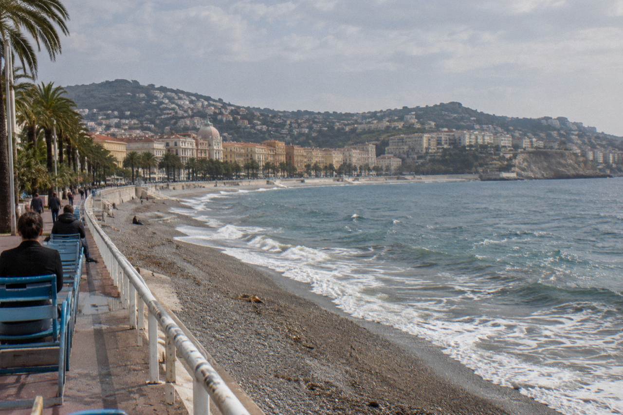 The old town of Nice with pastel buildings and the Mediterranean coastline in the distance