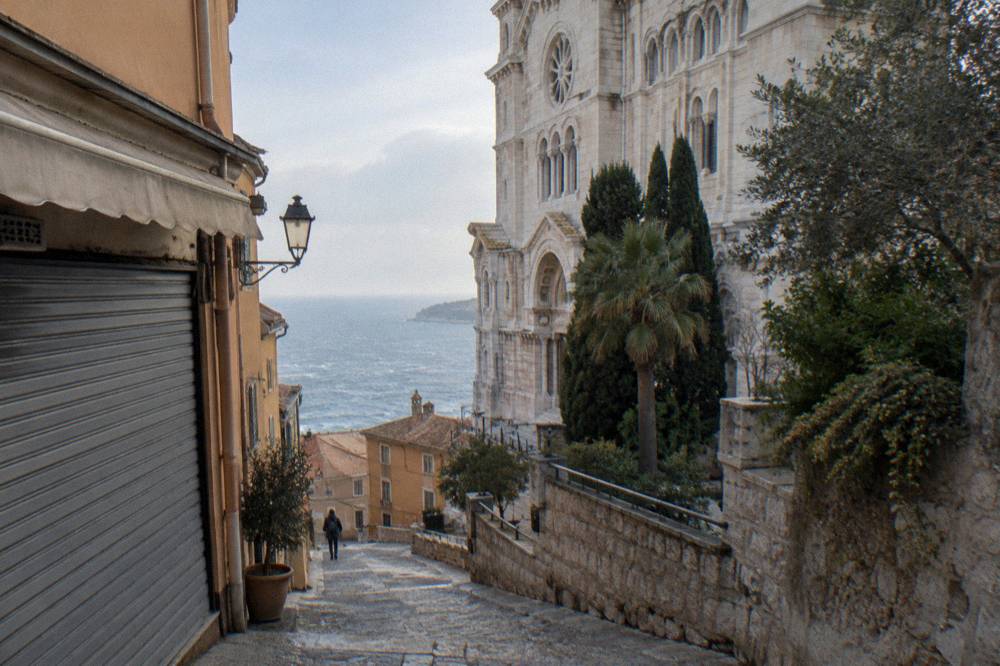 Empty stone streets of the Monaco old town in soft winter light with the sea in the distance