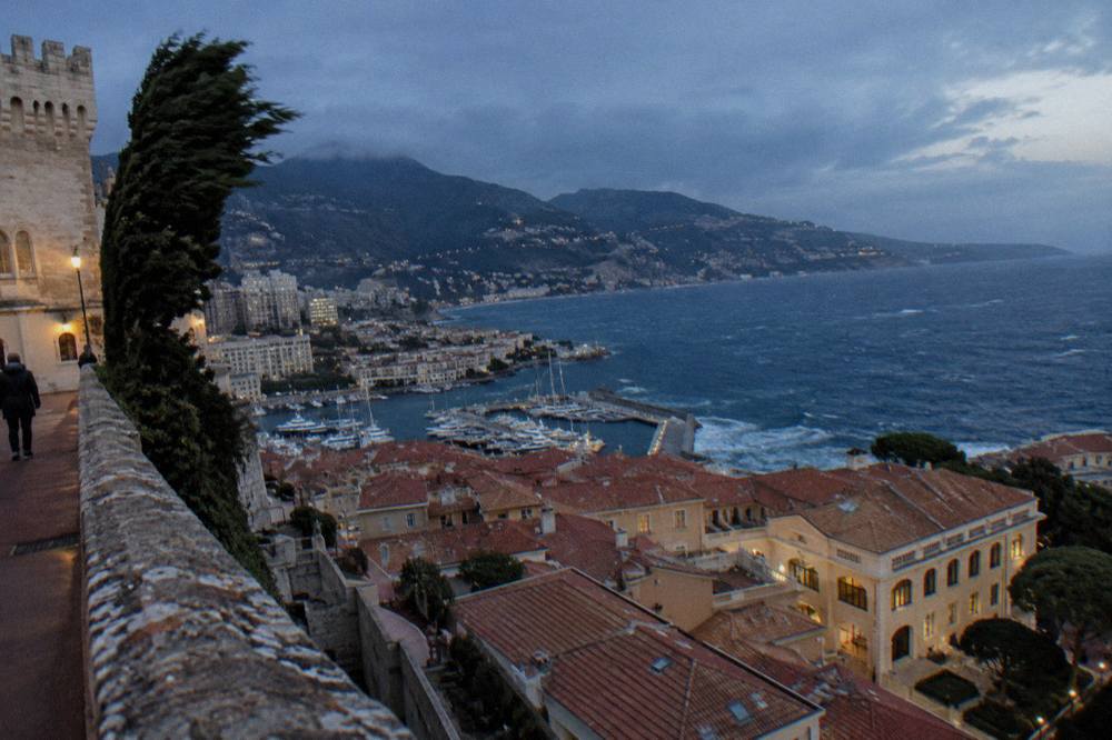 View over Monaco rooftops toward the French hillsides rising behind the principality