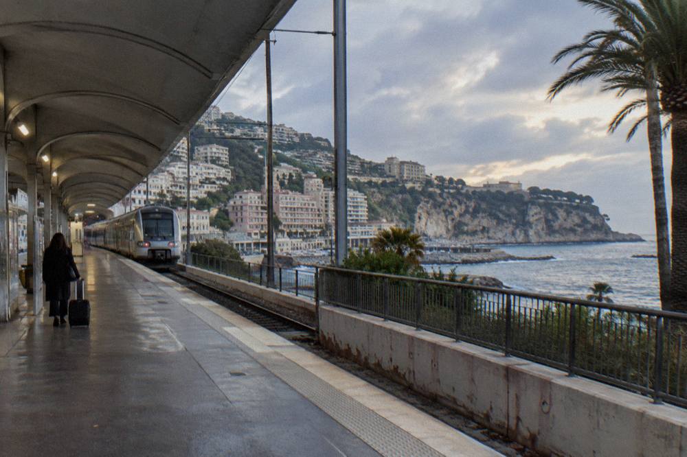 Railway platform beside the Mediterranean with a regional train at the station