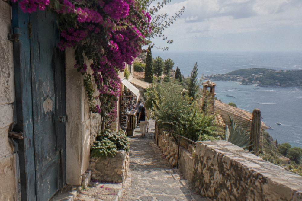 Narrow stone street in a hilltop village with shops and bright flowers