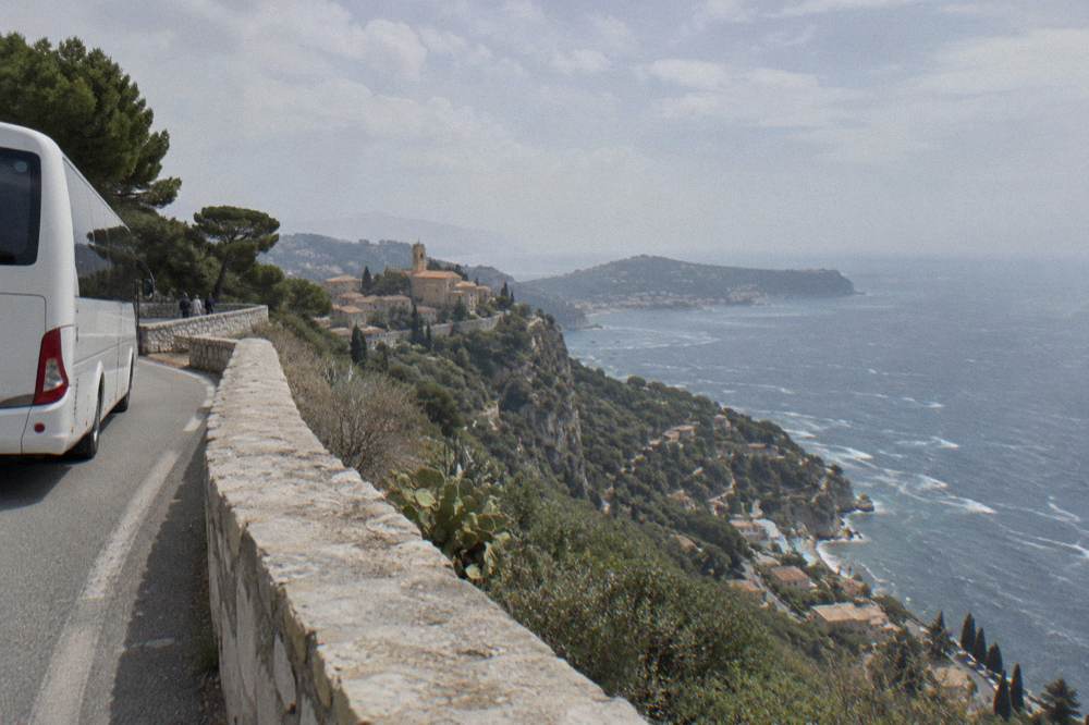 Tour coach parked on a coastal road above the Mediterranean near Eze
