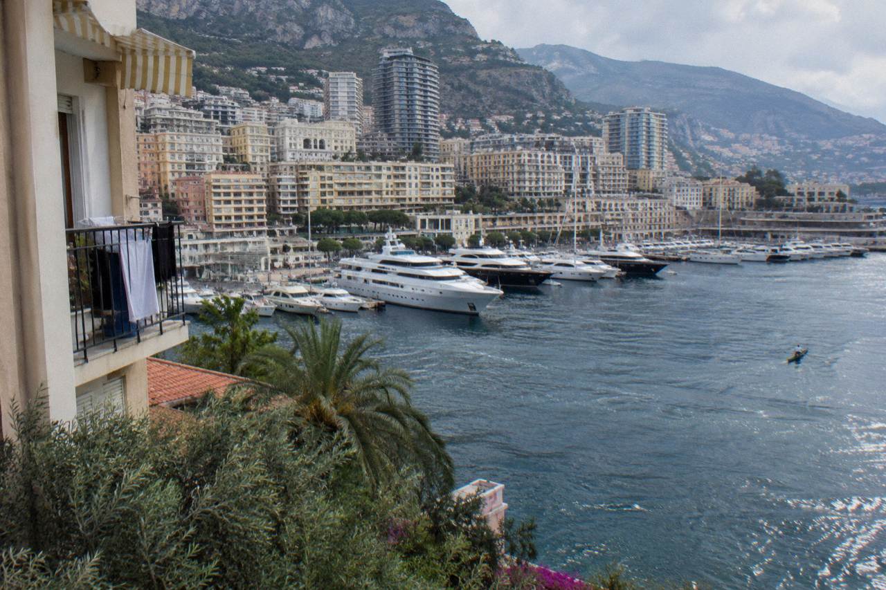 View over Monaco harbor from the hillside with luxury buildings and yachts along the waterfront