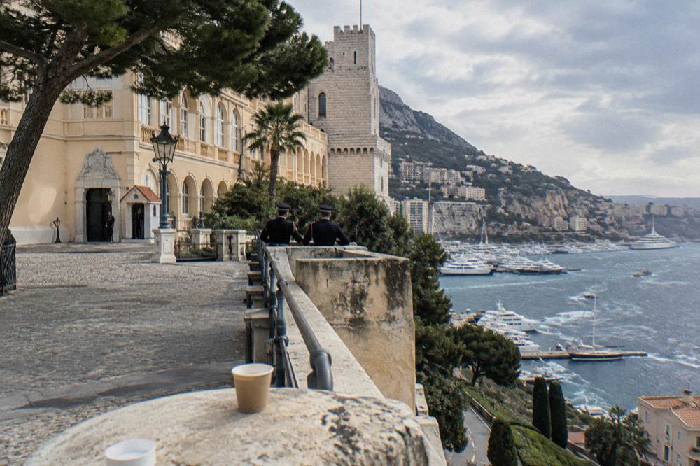 Palace square with stone facades and a view over a harbor of yachts
