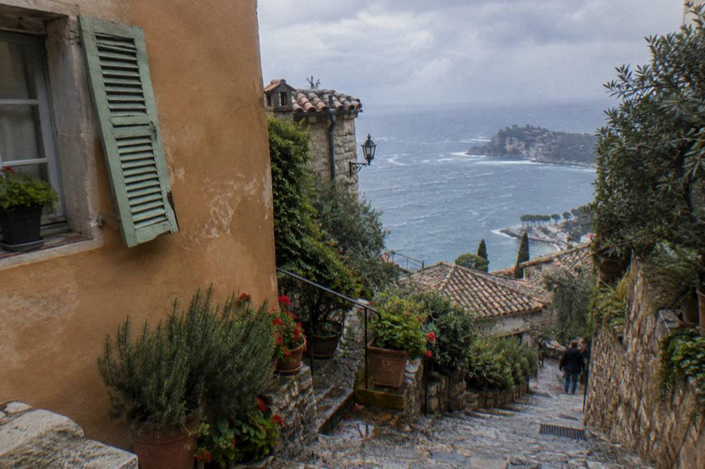 Winding stone staircase between old village houses with potted plants