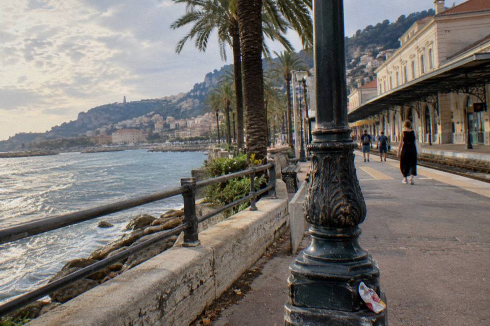 Seafront promenade in Menton with palm trees along the bay
