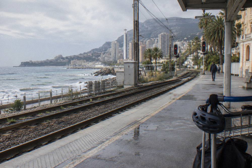 Menton train station platform with the Mediterranean visible beyond the tracks