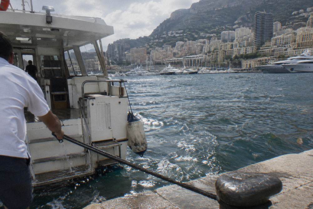 Passengers boarding a small excursion boat at a quay in Port Hercule