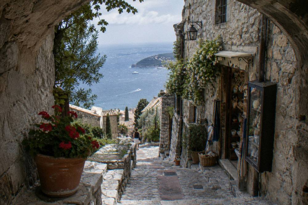 Narrow stone lane in a hilltop village with shops along the walls