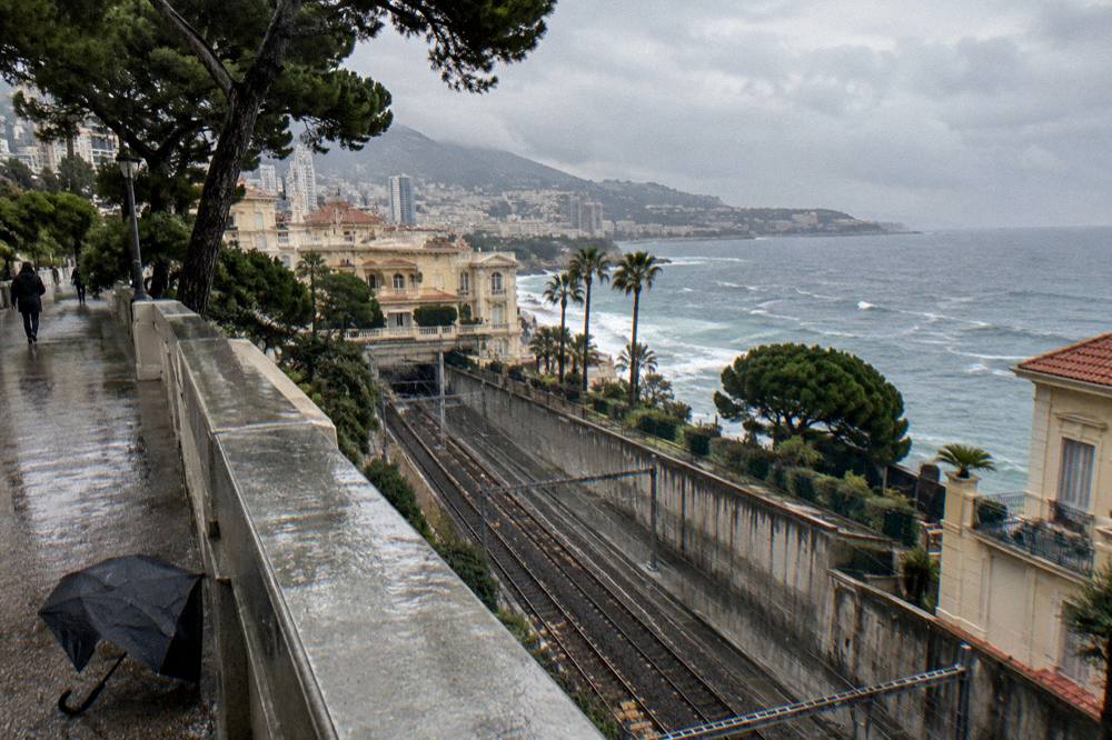 Coastal highway curving along cliffs above the sea toward a distant city