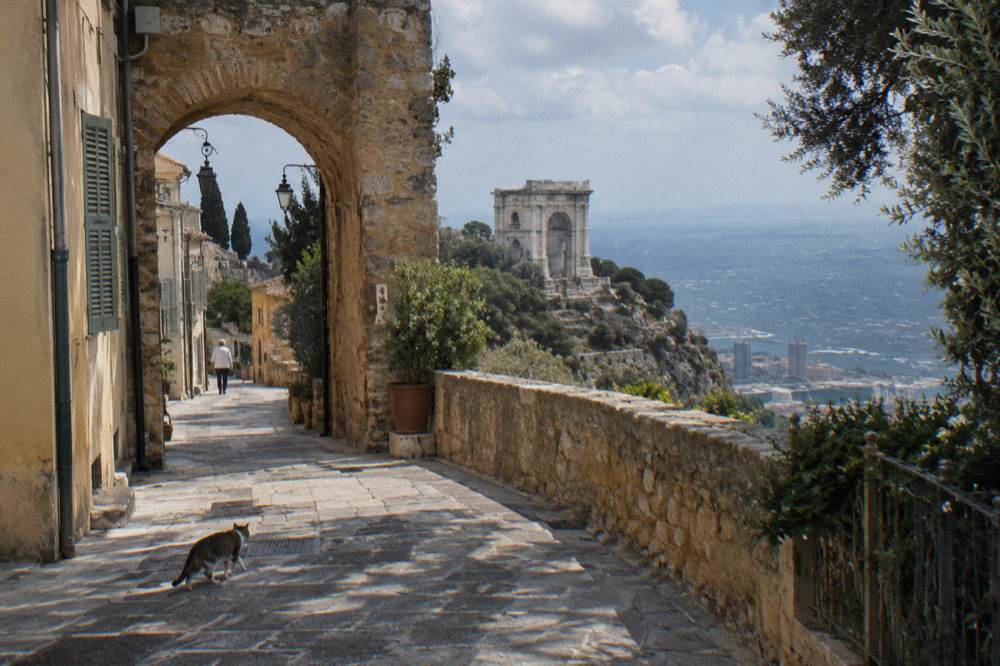 Narrow stone street of a quiet hilltop village with an arched passage and shuttered walls