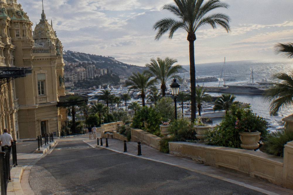 Steep street descending from Casino Square toward the Monaco harbor lined with apartment buildings