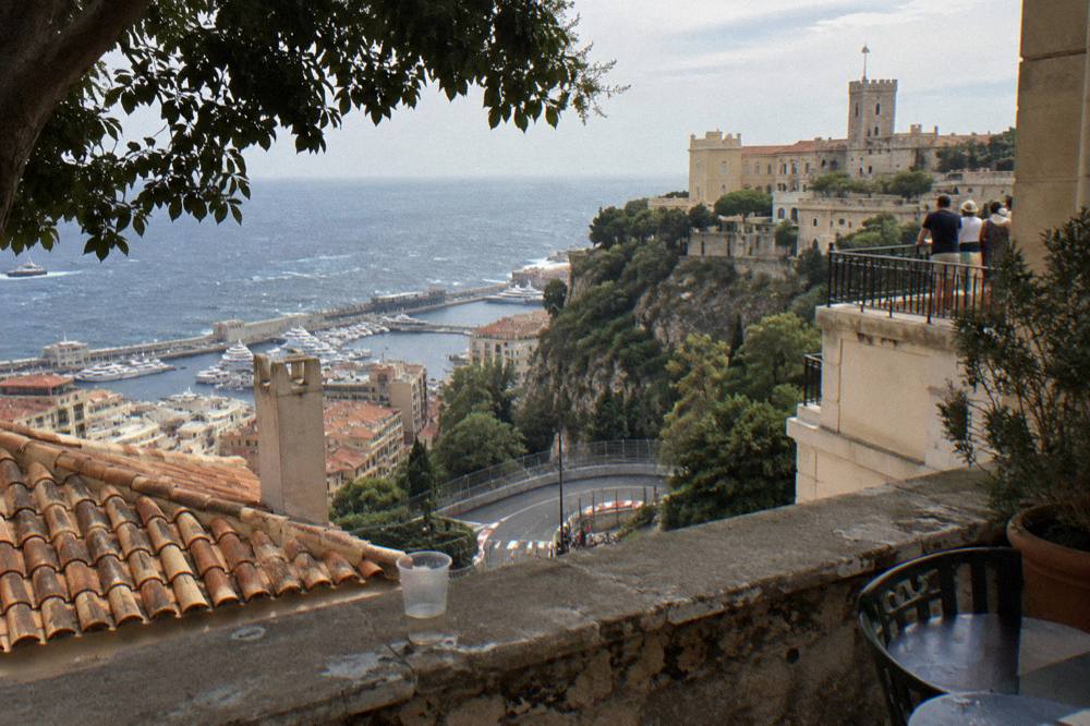 Crowds watching from a Monaco terrace above the race circuit rooftops and sea