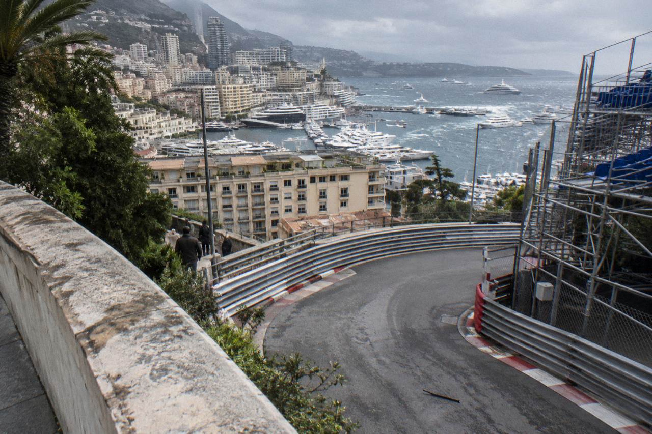 Grand Prix barriers and grandstands lining the Monaco street circuit with the harbor behind