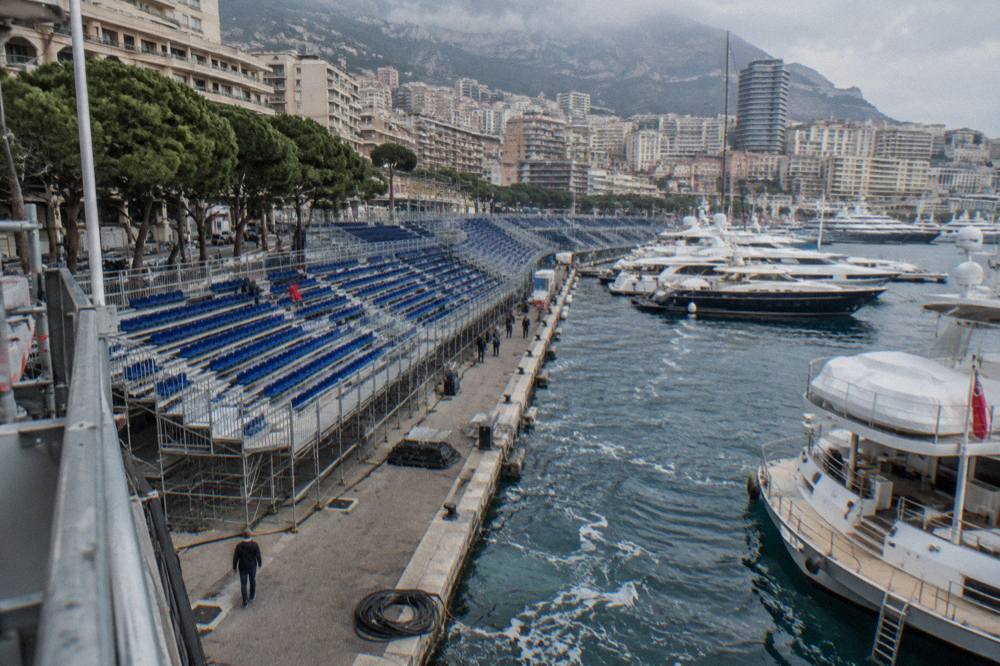Grandstands lining the Monaco street circuit with yachts moored in the harbor below