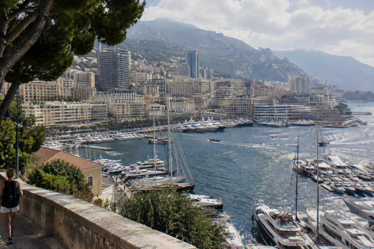 Harbor at Monaco with yachts moored along the quay and hillsides rising behind the buildings