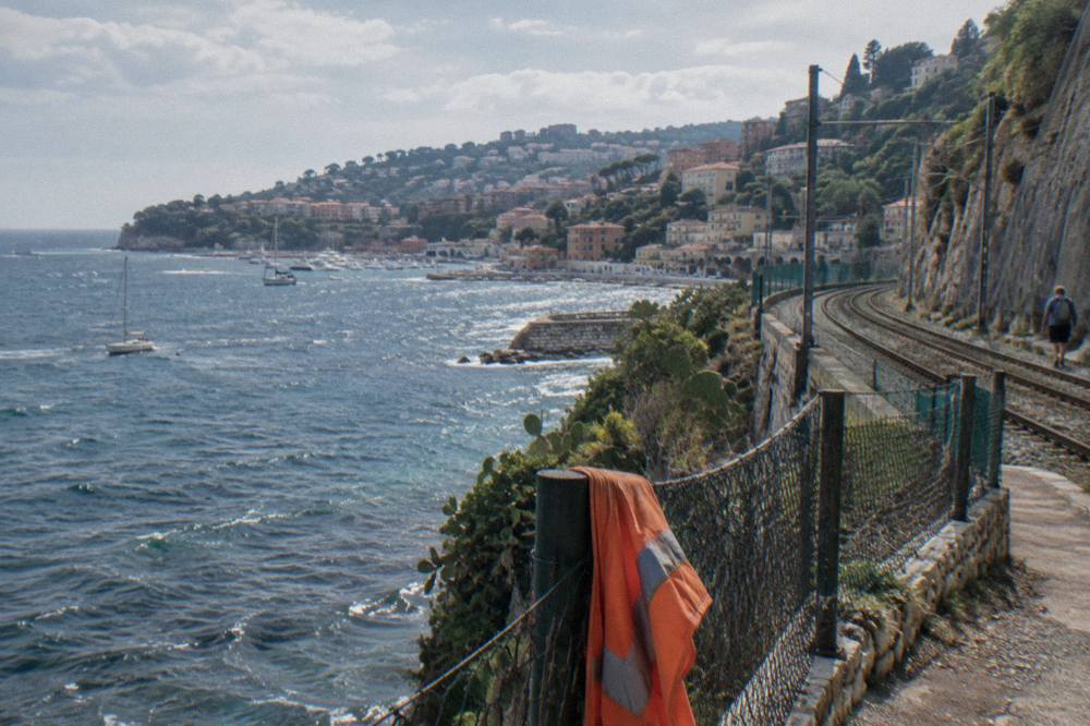 Coastal railway tracks curving along the cliffs between Nice and Monaco with the sea beyond