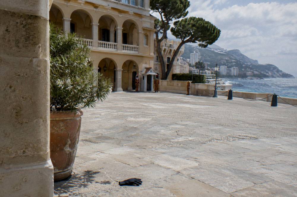 Stone palace courtyard with striped guard uniforms and classical architecture under a clear sky