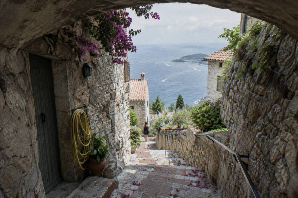 A narrow village lane of stone arches and shaded steps