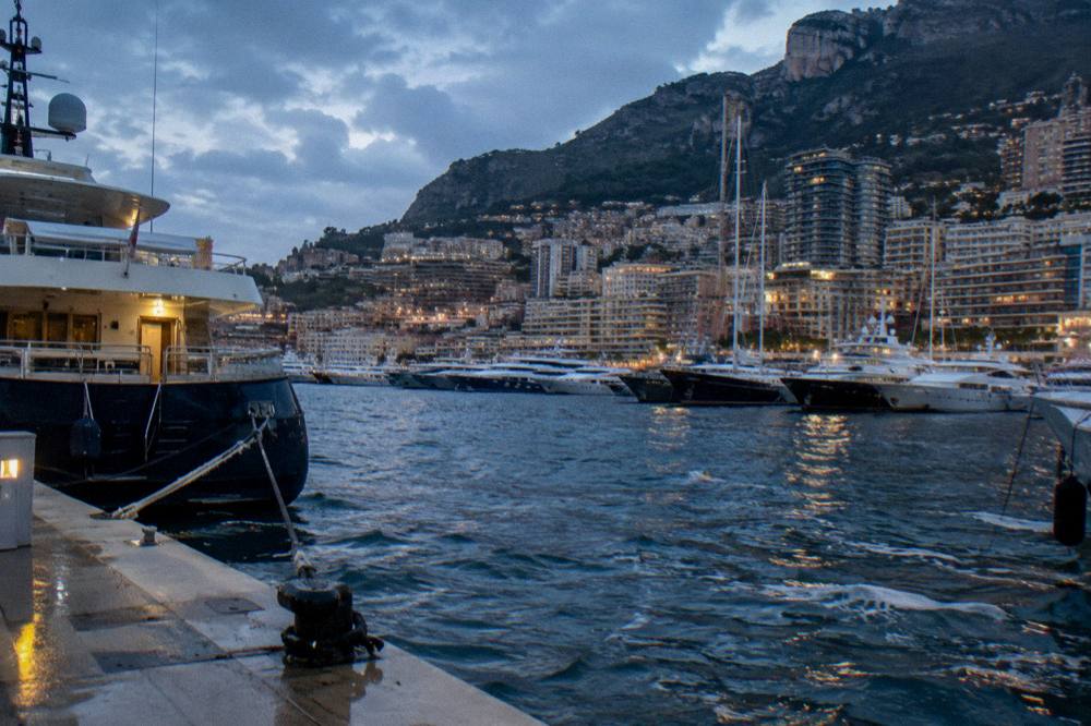 Harbor moorings with yachts and hillsides at dusk