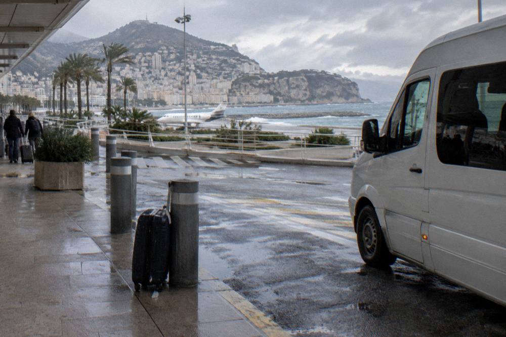 Tour minibus parked on a corniche overlook above the Riviera coastline