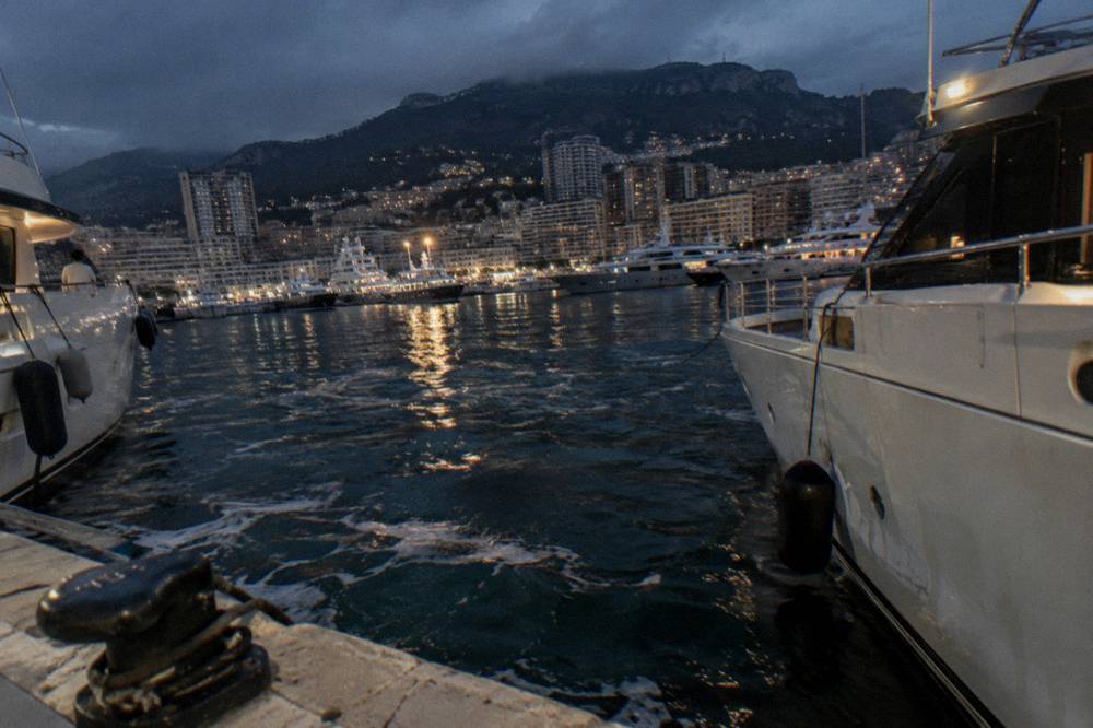 Port Hercule at night with yacht lights reflecting on still water