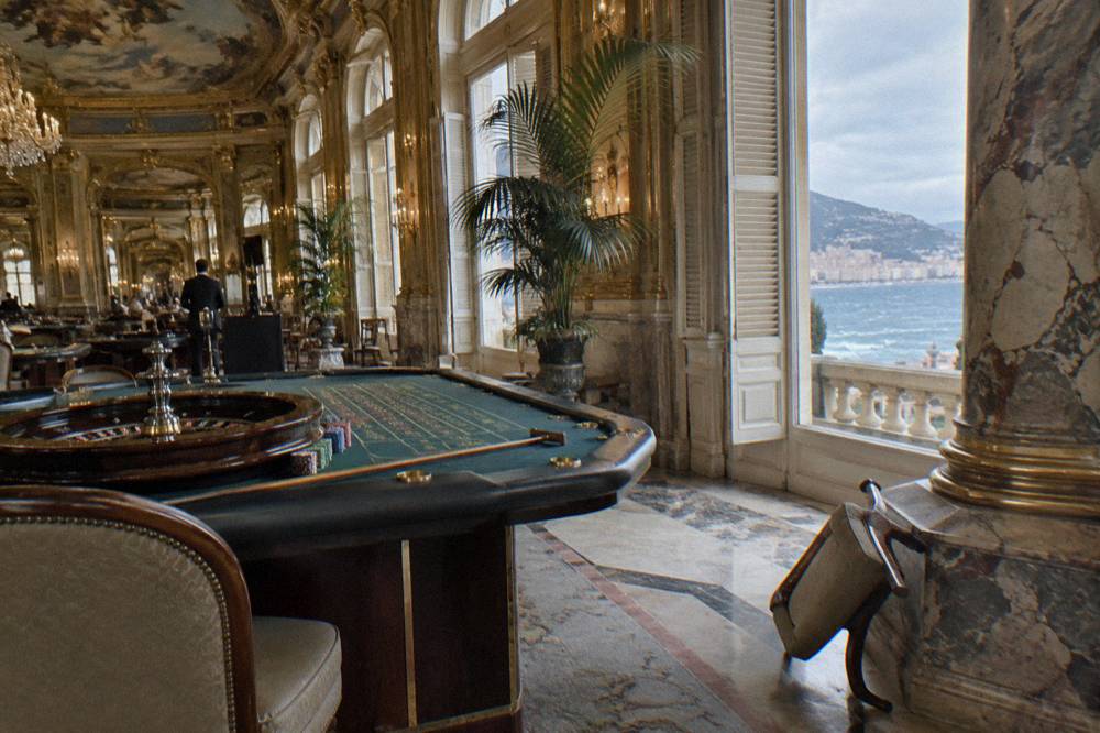 Gilded gaming salon with roulette table and ornate ceiling in Monte Carlo