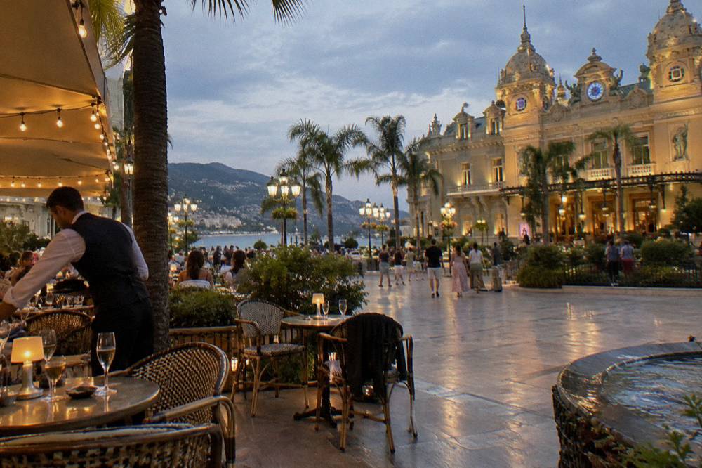 Casino square illuminated at night with cafes and palm trees in Monte Carlo