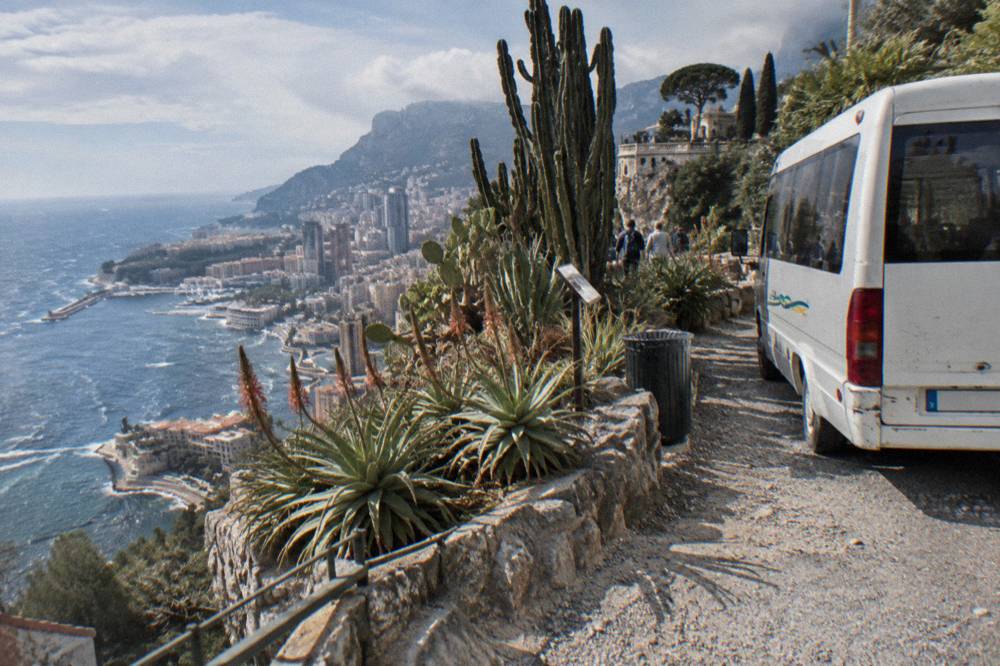 Tour minibus parked on a coastal road overlook above the Mediterranean