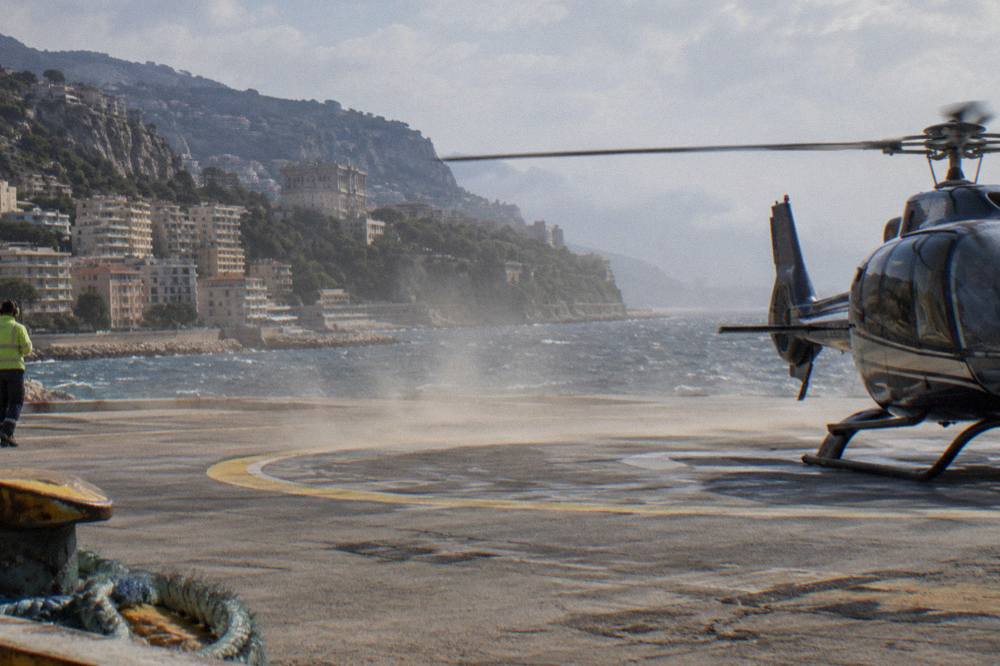 A helicopter on the helipad at Nice airport with the Mediterranean in the background