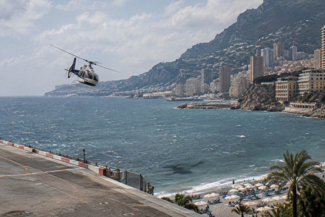 A light helicopter flying above the Mediterranean coastline between Nice and Monaco