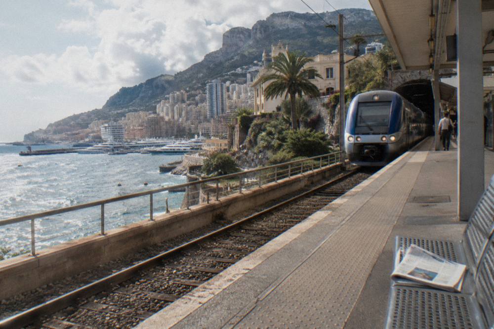 Train arriving at Monaco Monte Carlo station above the harbor