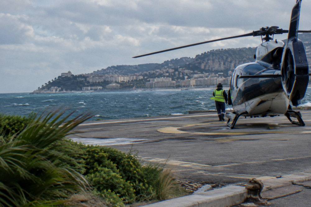 Helicopter on the Nice airport helipad with the Riviera coastline behind