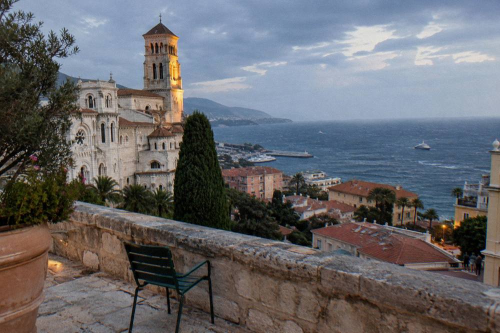 Blue evening sky over Monaco rooftops and the sea from a hillside terrace