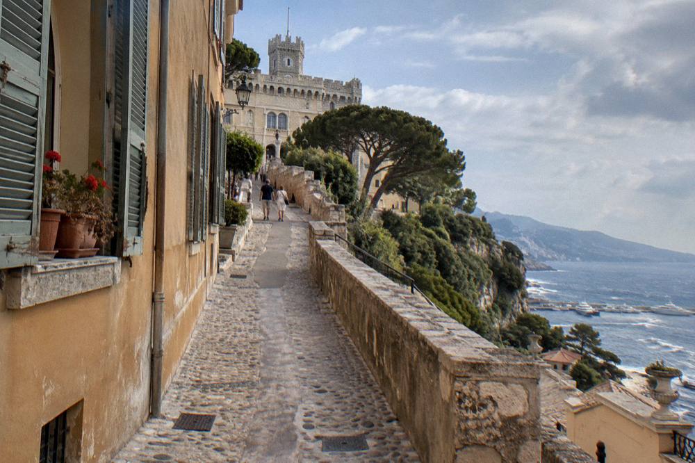 Cobbled lane of stone houses in Monaco old town leading toward the Palace square