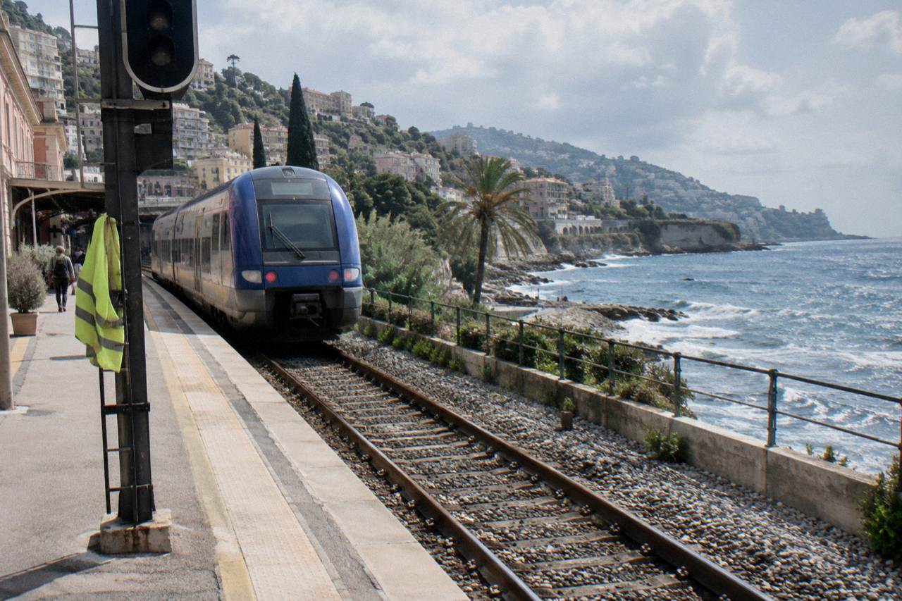 A regional train on the coastal line between Nice and Monaco with the Mediterranean behind it