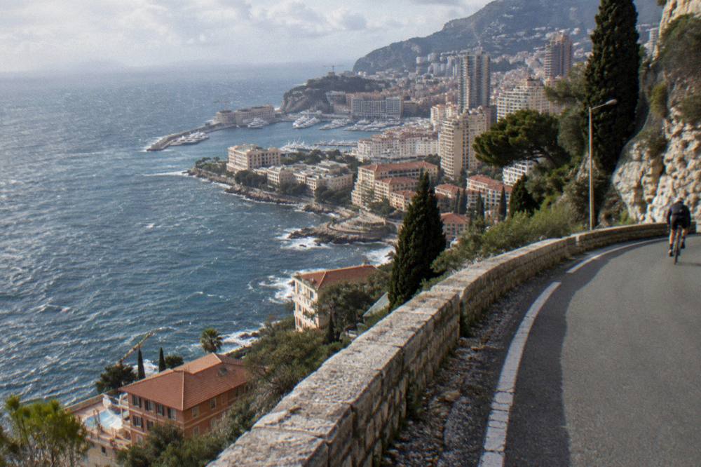 Coastal road curving along cliffs between Villefranche-sur-Mer and Monaco with sea horizon